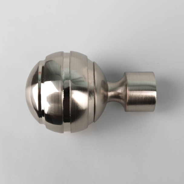 Ball-shaped silver ending for curtain eaves on grey background - Photo, image
