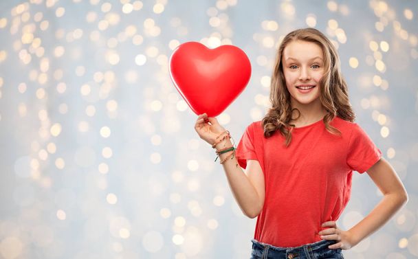 smiling teenage girl with red heart shaped balloon - Фото, зображення