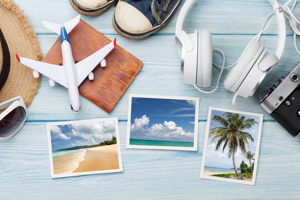 concepto de vacaciones con sombrero de sol, cámara, pasaporte, juguete de avión, auriculares y fotos de fin de semana sobre fondo de madera
 - Foto, Imagen