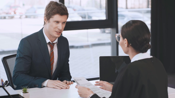 cheerful man giving resume, smiling, standing up and shaking hands with businesswoman in office  - Footage, Video