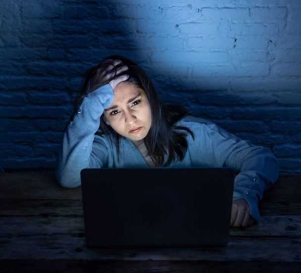 Dramatyczny portret smutnego przerażonej młodej kobiety podkreślił i zaniepokojony patrząc na laptopa cierpienia cyberprzemocy i molestowania. Ofiara nadużyć online i zastraszanie przez Stalker. W niebezpieczeństwach związanych z Internetem. - Zdjęcie, obraz