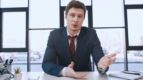 hombre guapo hablando y haciendo gestos durante la entrevista de trabajo en la oficina
  - Metraje, vídeo