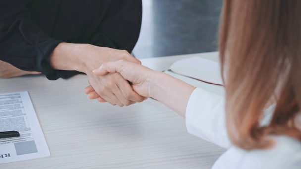 cropped view of businesswoman and man shaking hands after job interview   - Materiał filmowy, wideo