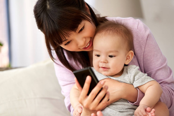 asian mother with baby son taking selfie at home - Foto, imagen