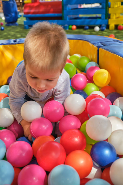 Boy is playing in the ball pool at children's playground - 写真・画像