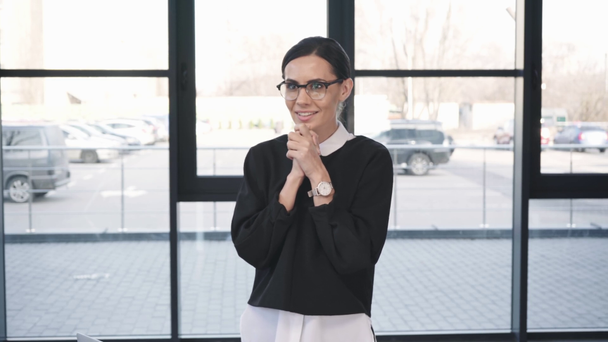 atractiva mujer preocupada en gafas de pie con las manos apretadas antes de la entrevista de trabajo
  - Metraje, vídeo