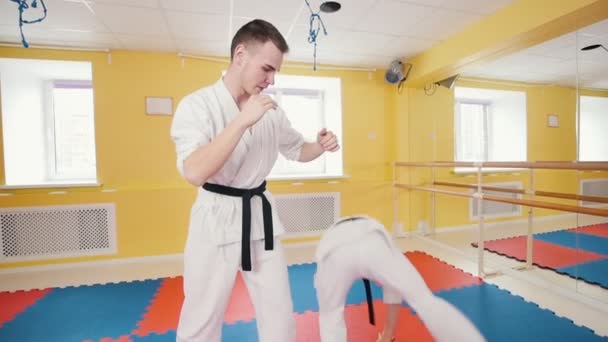Atletik erkekler aikido dövüş sanatı meşgul. Bir adam bacakları ile onun saldıran becerilerini gösterir - Video, Çekim