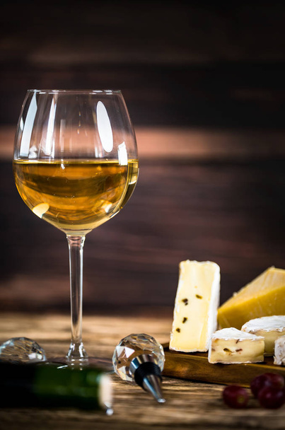 Étvágygerjesztő sajt szőlő és bor, fa háttérben - Fotó, kép