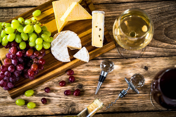Appetizing cheese with grapes and wine on wooden background - Zdjęcie, obraz