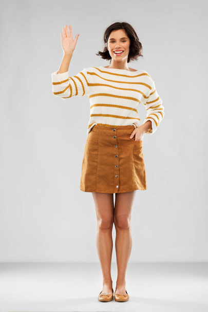 woman in pullover, skirt and shoes waving hand - Fotoğraf, Görsel