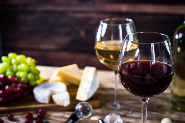 Appetizing cheese with grapes and wine on wooden background - Photo, Image
