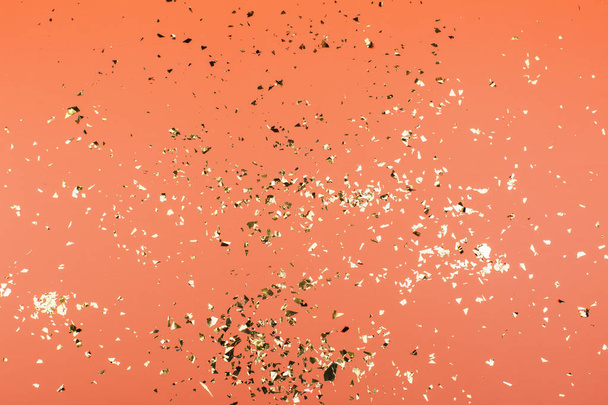Golden sparkles on coral pastel trendy background. Festive backdrop for your projects. - Zdjęcie, obraz