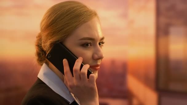 Flirty female manager talking phone, personal conversation on work place - Filmagem, Vídeo