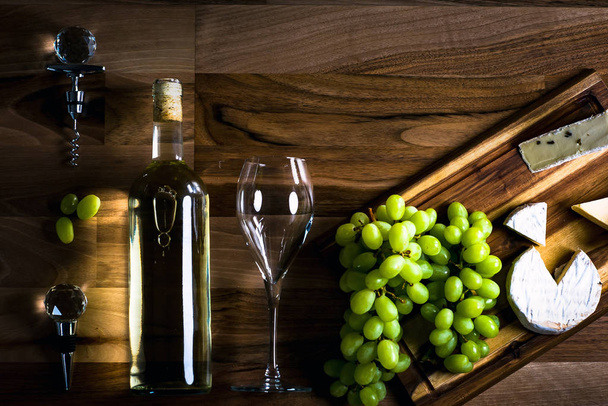 Queso apetitoso con uvas y vino sobre fondo de madera
 - Foto, Imagen