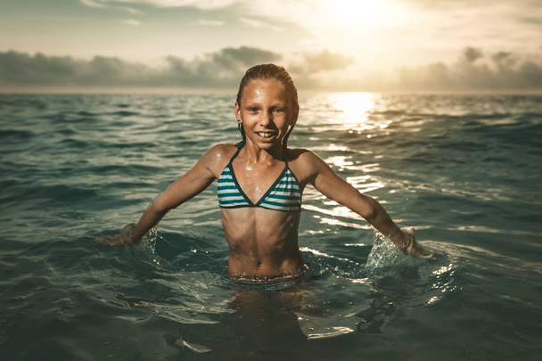 pieni tyttö hauskaa meren aallot
 - Valokuva, kuva