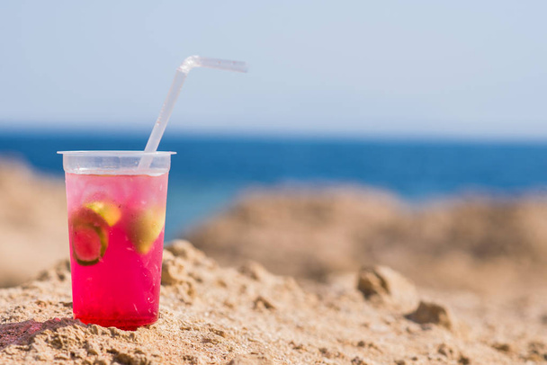 Coquetel brilhante em uma praia de verão contra o mar azul
 - Foto, Imagem
