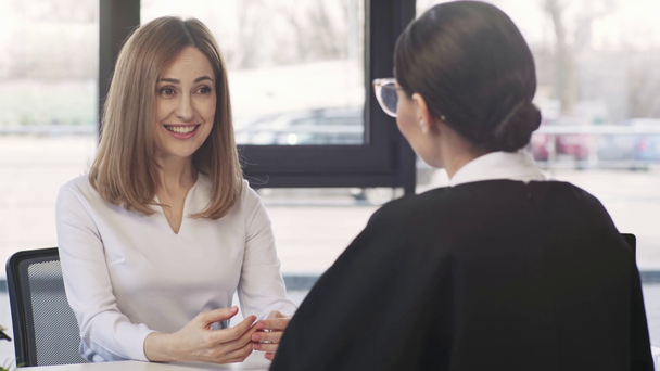 attraente donna parlando e gesticolando durante il colloquio di lavoro con donna d'affari
  - Filmati, video