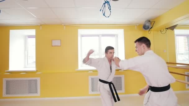 Dos hombres entrenando sus habilidades de aikido. Técnica de protección. Un hombre agarra a su oponente y lo arroja al suelo
 - Metraje, vídeo