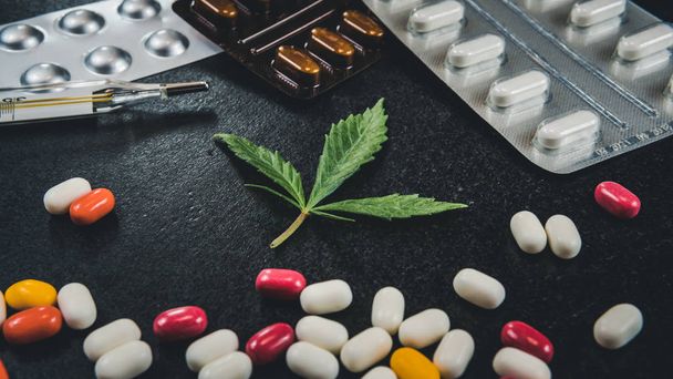Salud con marihuana medicinal. Hoja de cannabis y pastillas en bl
 - Foto, Imagen