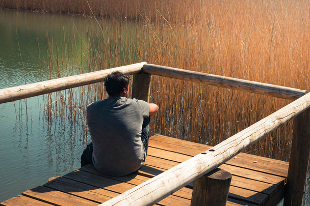 ein junger Mann allein auf einem See, Porträt, la arboleda, baskisches Land - Foto, Bild