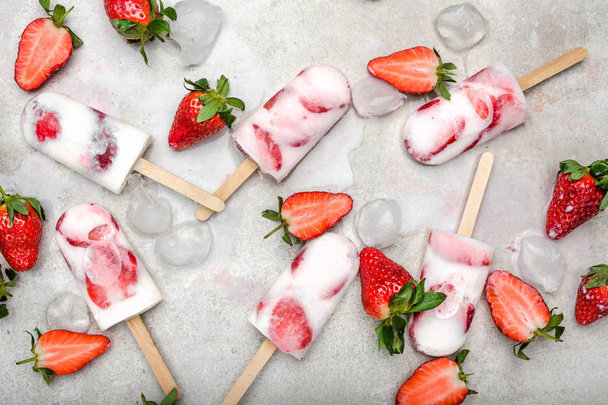 Fruit popsicle with frozen strawberry and yogurt, ice cream on stick - Foto, imagen