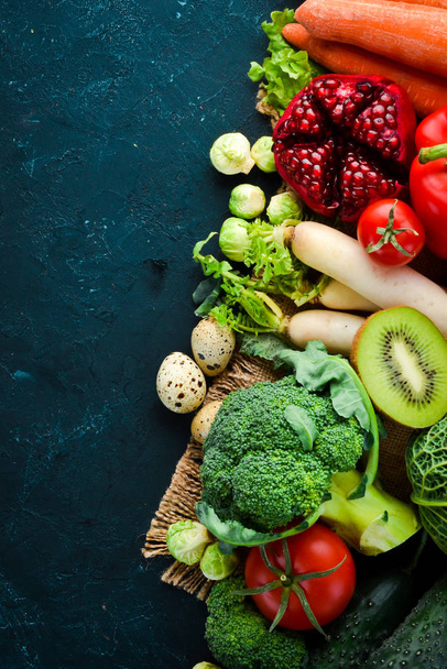 Organic food on a black stone background. Vegetables and fruits. Top view. Free copy space. - 写真・画像