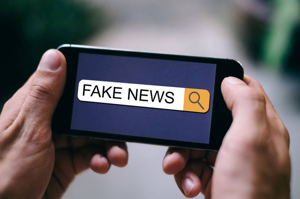 Koncepcja SEO News: bliska fake News jest wyświetlany w pasku wyszukiwania na wyświetlaczu smartphone - Zdjęcie, obraz