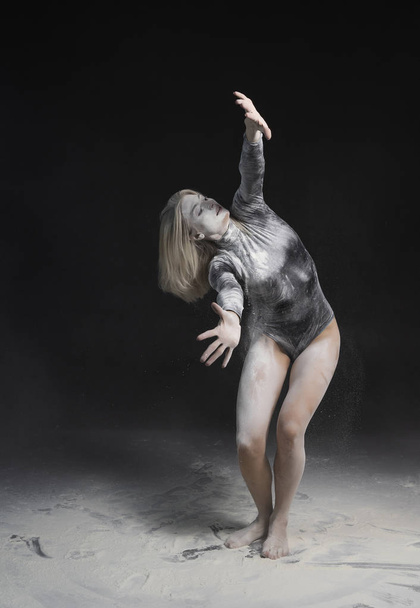 Beautiful slim girl wearing a black gymnastic bodysuit covered w - Fotografie, Obrázek