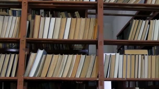 Kütüphanedeki raflarda birçok eski kitap - Video, Çekim