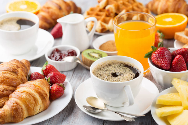 Континентальный стол для завтрака с кофе, апельсиновым соком, круассаном
 - Фото, изображение