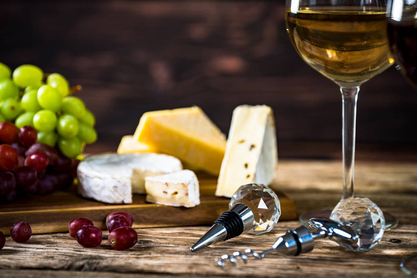 Appetizing cheese with grapes and wine on wooden background - Valokuva, kuva