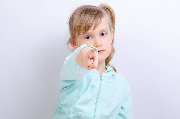 Το παιδί δείχνει το δάχτυλό του προς τα εμπρός σε γκρίζο φόντο - Φωτογραφία, εικόνα