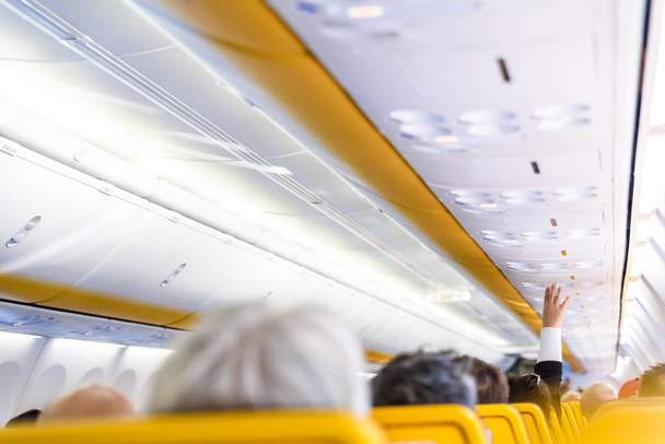 Pasajero de negocios en un avión que solicita asistencia al mayordomo
 - Foto, Imagen