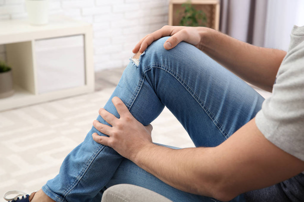 Man suffering from leg pain at home, closeup - Zdjęcie, obraz