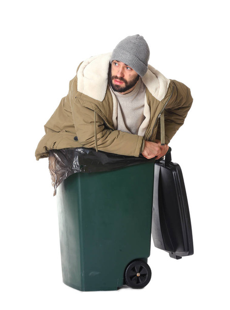 Poor homeless man in trash bin isolated on white - Foto, afbeelding