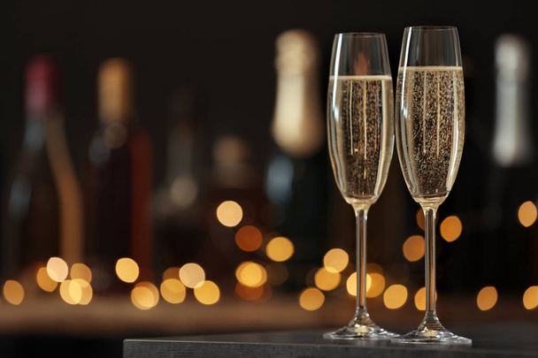 Glasses of champagne on table against blurred background. Space for text - Фото, изображение
