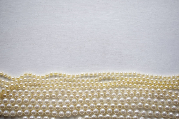 Shine collana di perle su uno sfondo bianco. Posa piatta, vista dall'alto
 - Foto, immagini