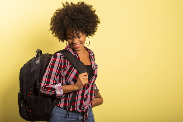 young african student with backpack on the back on yellow background. - Foto, immagini