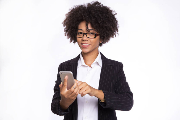 Black business woman using smartphone, texting and smiling, isolated on white background - 写真・画像