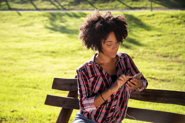 Portrait of a young african american woman listening to music on cell phone - Imagem. - Foto, Imagem