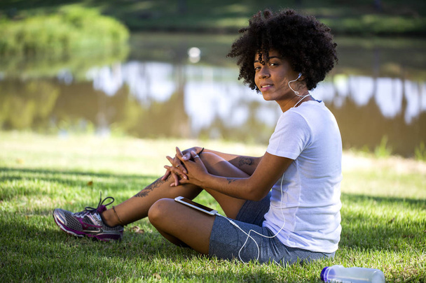 Portrait of a young african american woman listening to music on cell phone - Photo, Image