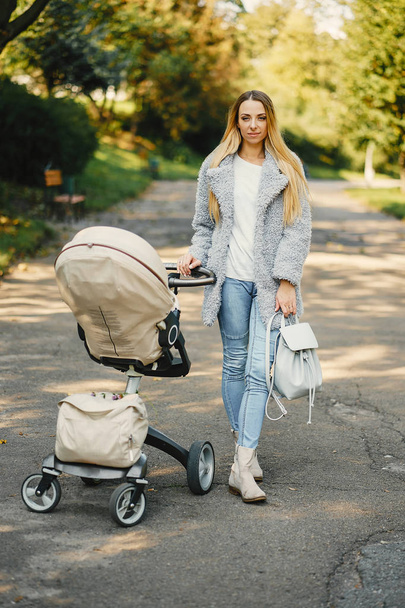 young mother pushing a stroller - Foto, Bild