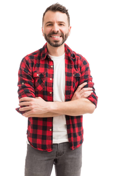 Attractive man crossing arms while standing against plain background - Photo, image