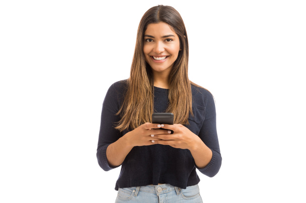 Πορτρέτο του όμορφη νεαρή γυναίκα χρησιμοποιώντας τα μέσα κοινωνικής δικτύωσης στο κινητό τηλέφωνο ενάντια στο λευκό - Φωτογραφία, εικόνα