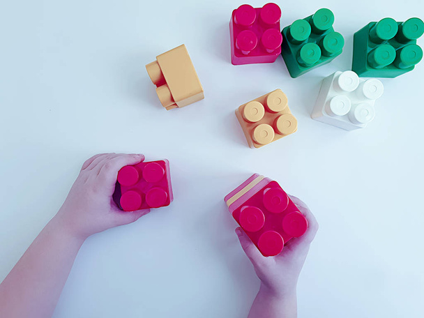 ręce dziecka grając z bloków plastikowych na białym tle - Zdjęcie, obraz
