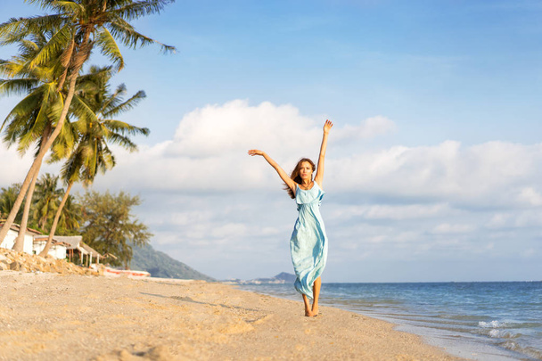 girl walks on a tropical beach in a dress - Φωτογραφία, εικόνα
