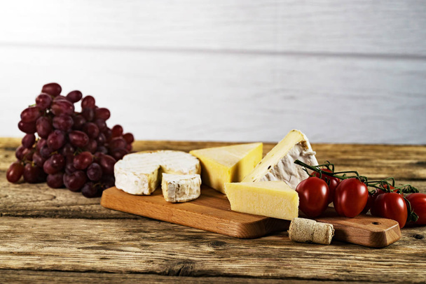 Ορεκτικό τυρί με σταφύλια σε ξύλινο φόντο - Φωτογραφία, εικόνα