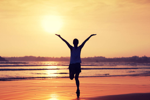 Щаслива вільна жінка на заході сонця на пляжі - Фото, зображення