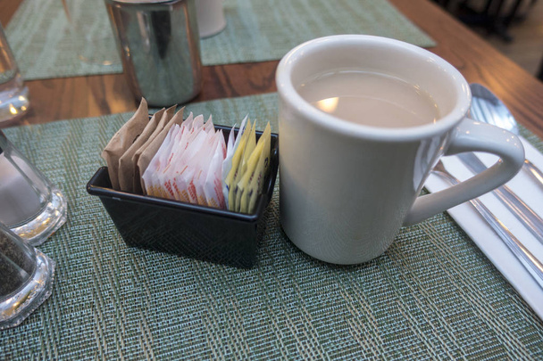 thé au café à une table de dîner avec divers sucre de portion unique m
 - Photo, image