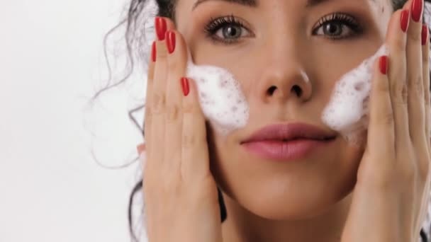Beautiful woman enjoys the process of cleaning the face - Imágenes, Vídeo